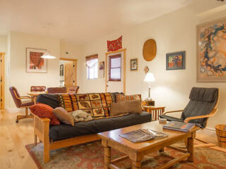 A cozy living room filled with eclectic furniture, colorful textiles, and southwestern art pieces