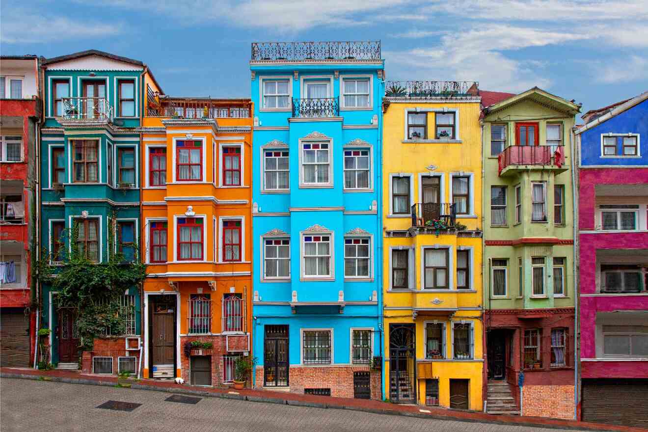 Colorful facades of buildings in a vibrant Istanbul neighborhood with balconies and greenery, reflecting the city's eclectic architecture.