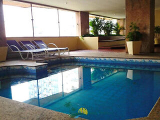 Relaxing indoor pool area at Apart Hotel Leblon Ocean with lounge chairs and tropical ambiance