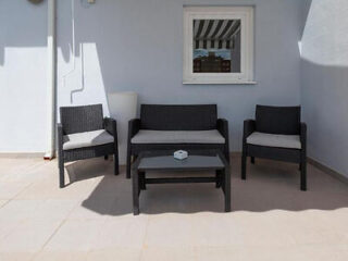 Comfortable outdoor seating area with rattan furniture on a spacious terrace