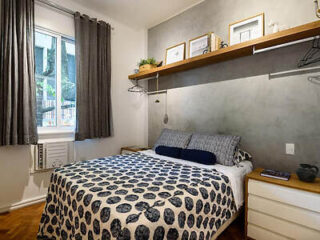 Charming and compact bedroom with a patterned bedspread and minimalistic decor in Studio Novo