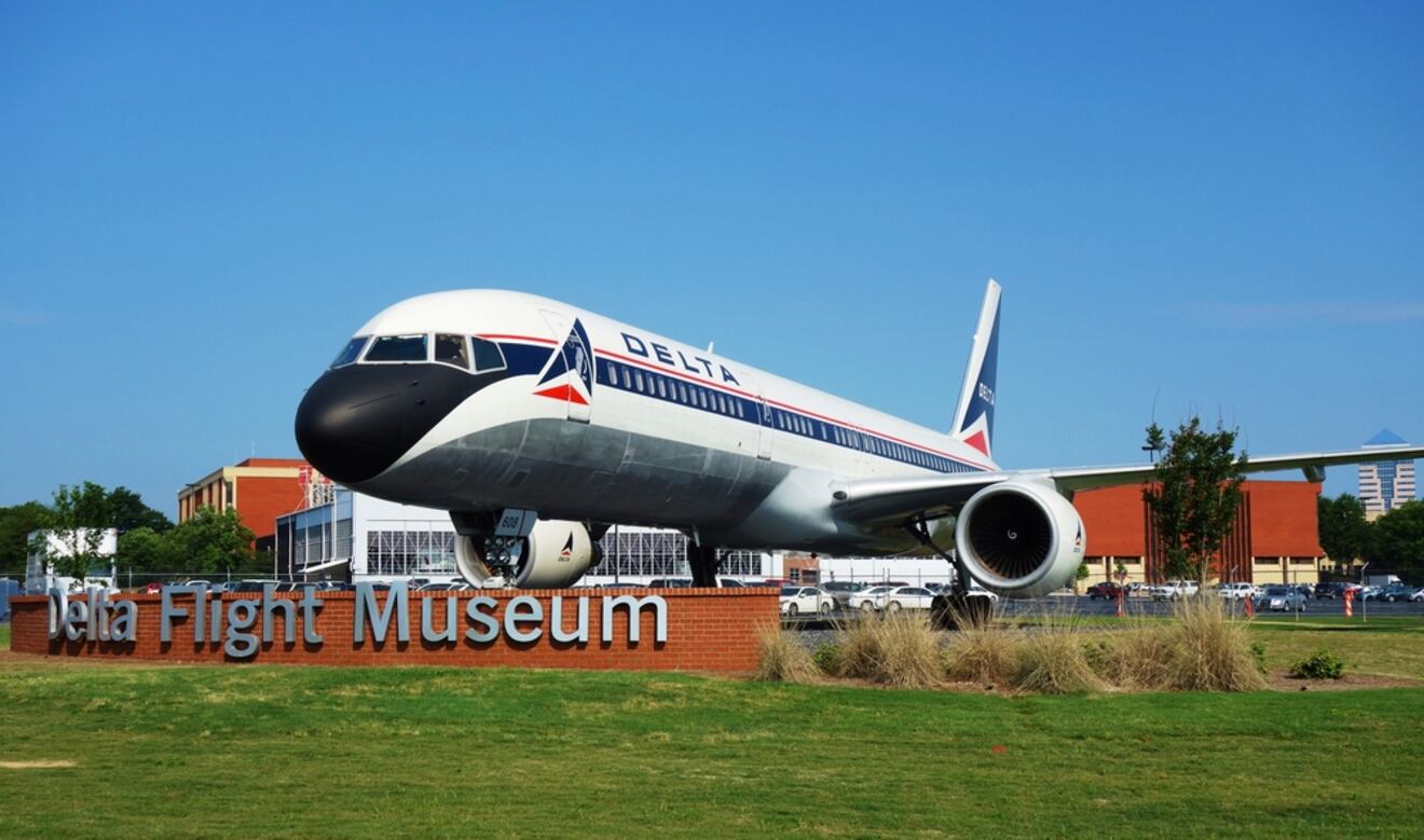 Delta Flight Museum exterior with a large Delta airplane on display, museum signage, and a clear blue sky in the backdrop