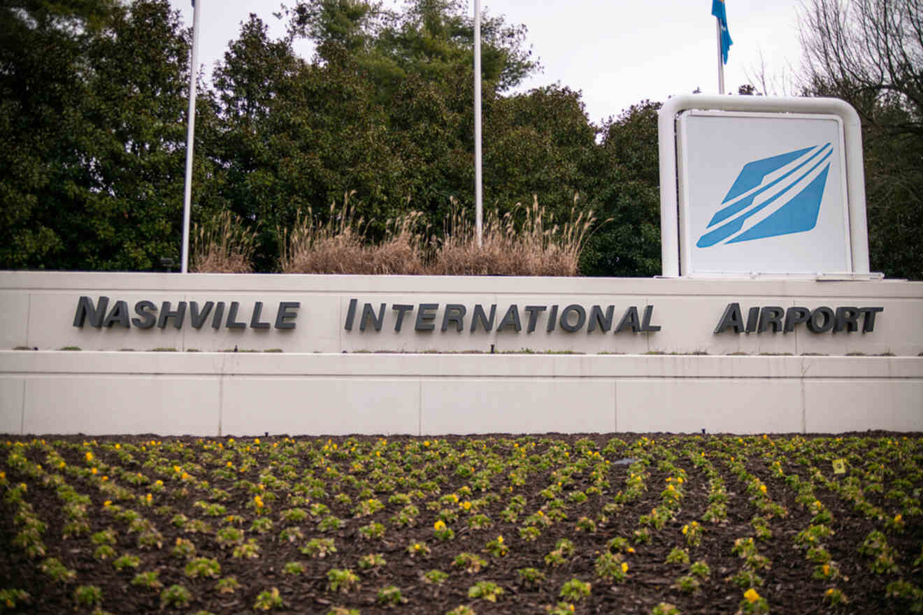 Entrance sign of Nashville International Airport, with the airport's logo, set among landscaped greenery