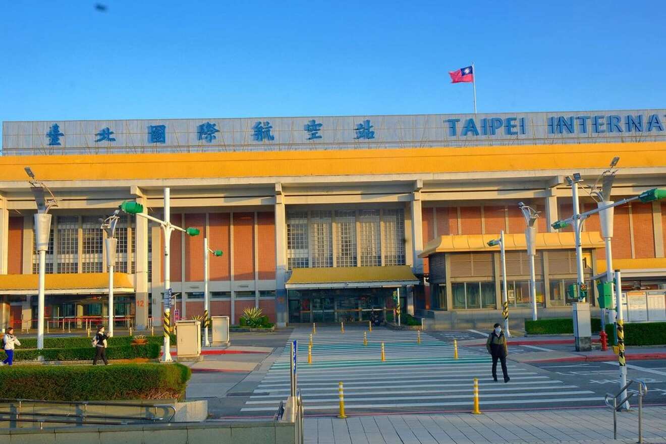 The front exterior of Taipei International Airport, bathed in golden sunlight, displaying its modern yet functional architectural design.
