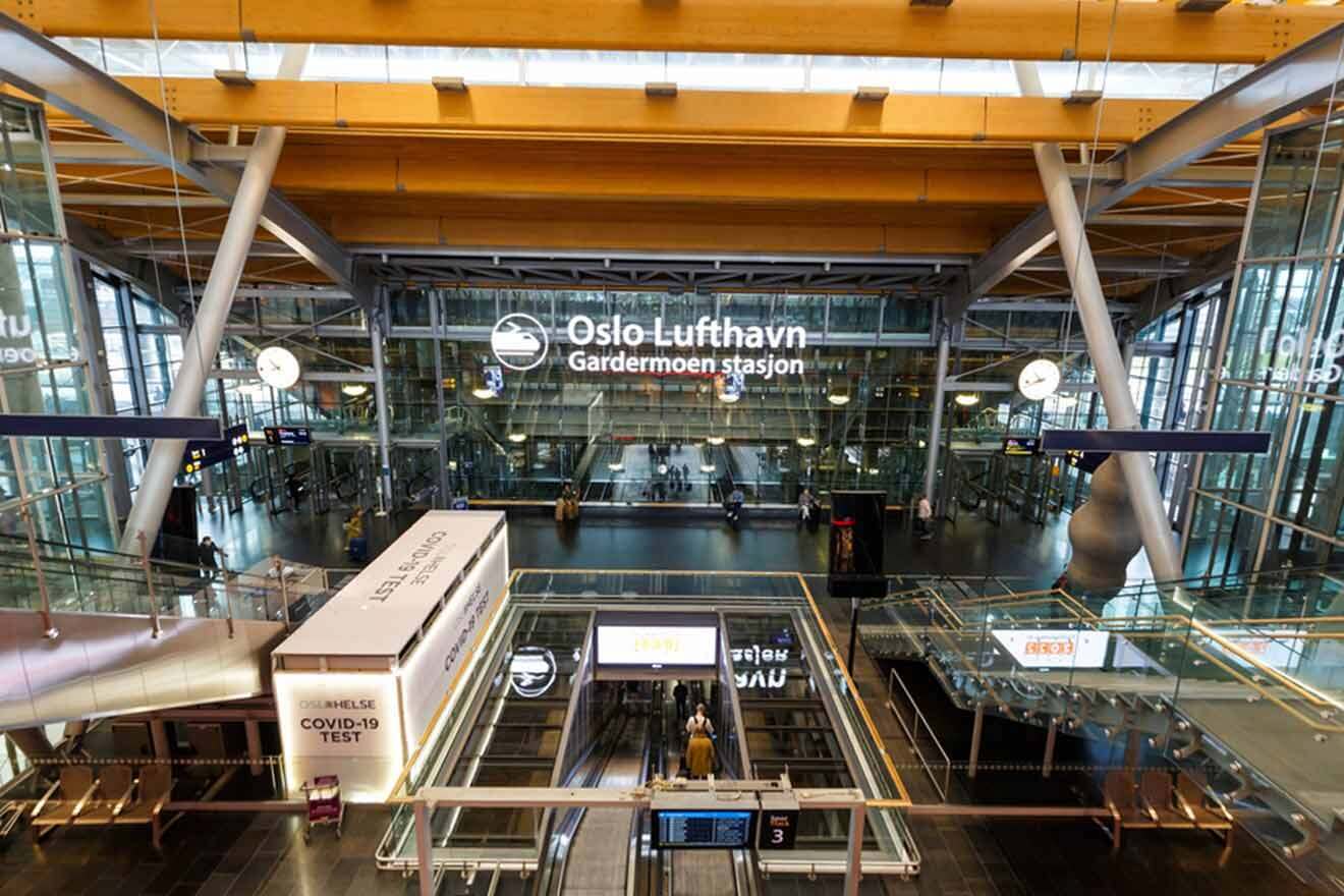 Interior of Oslo Gardermoen Airport with clear signage, modern architectural design, and passengers navigating the travel hub.
