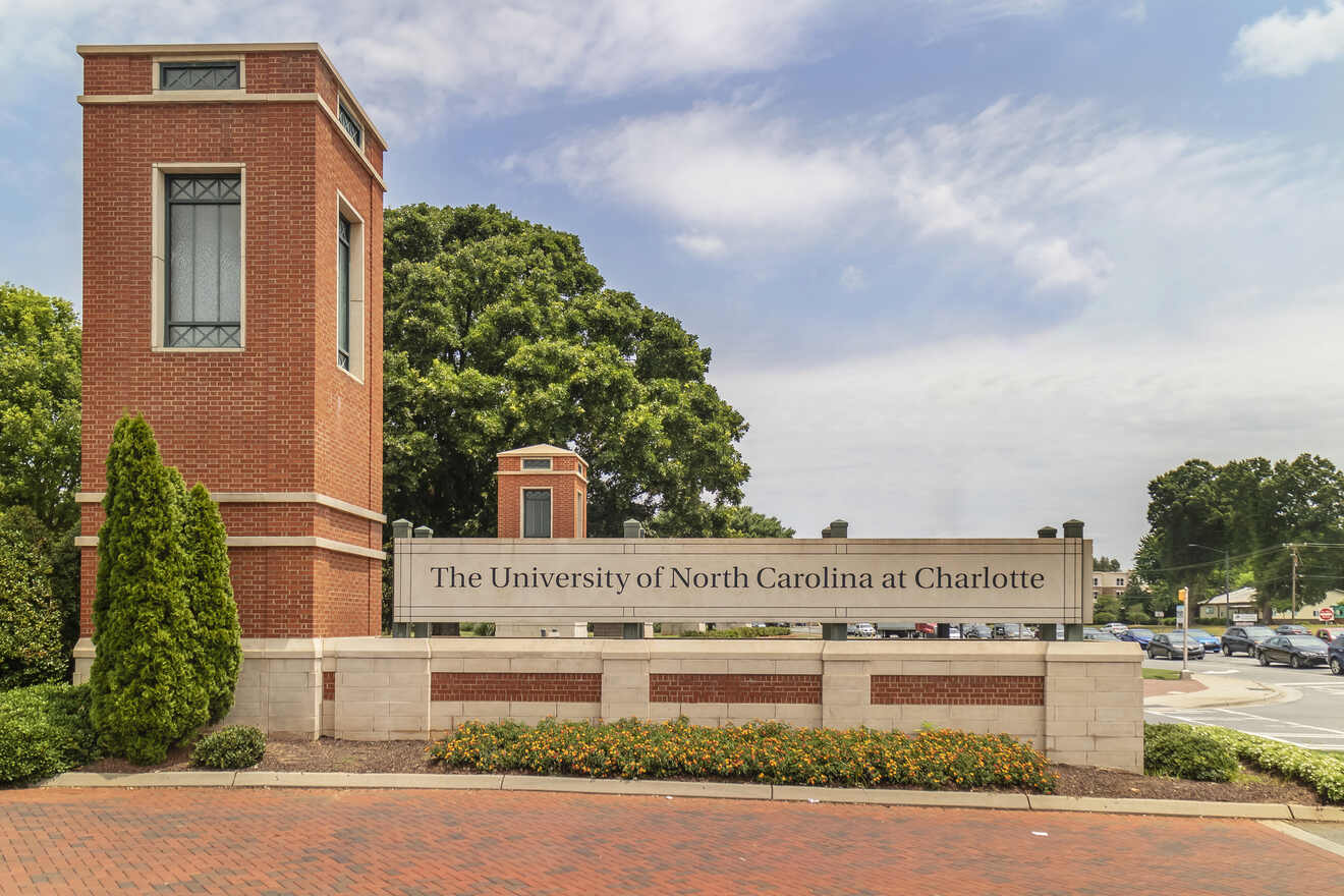 Entrance sign of The University of North Carolina at Charlotte with brick pillars and lush greenery