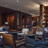 A sophisticated hotel lounge with rich wooden paneling, comfortable seating, and elegant blue accents, creating an atmosphere of luxury.