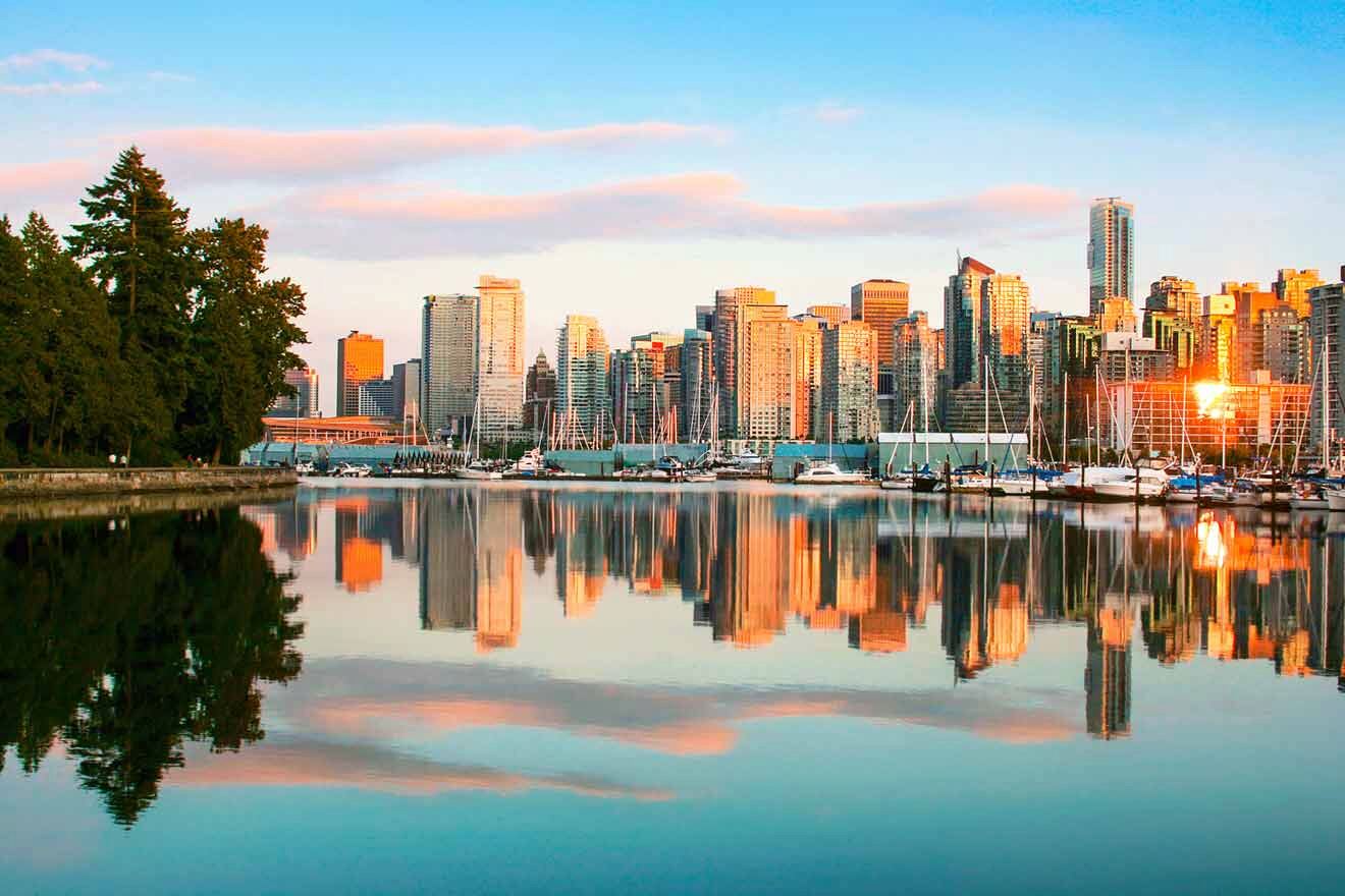 Sunset view of Vancouver's skyline reflected in the calm waters of the harbor with Stanley Park's greenery to the left