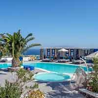 Luxurious hotel pool with surrounding palm trees and a view of the Aegean Sea