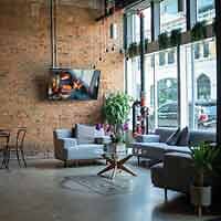 Chic lobby space in a boutique hotel, combining exposed brick, contemporary furnishings, and large windows for a welcoming vibe.