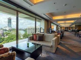 A hotel executive lounge with expansive windows offering a panoramic city view, plush seating, and a serene atmosphere.