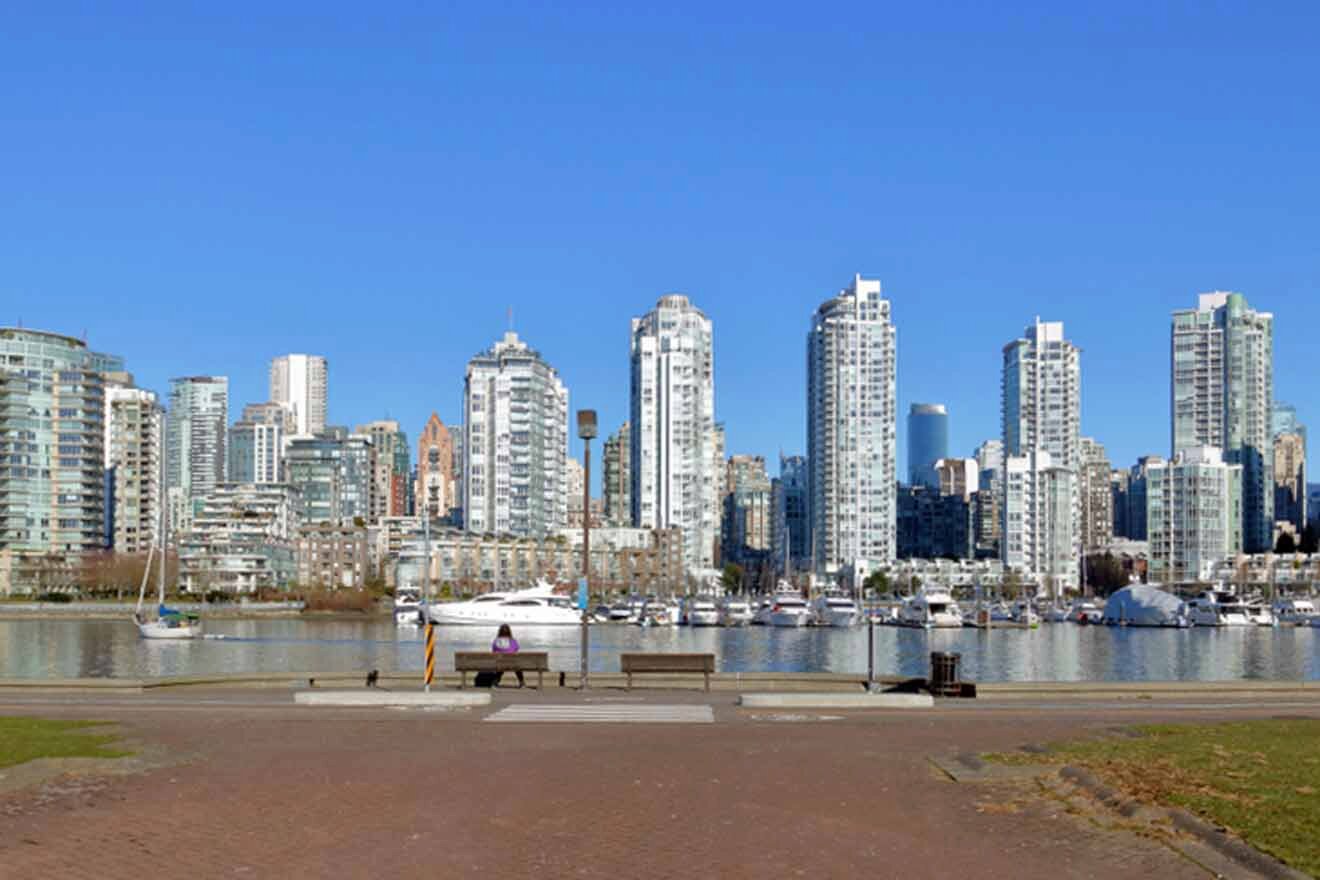 Vancouver's Downtown Core on a clear day with high-rise buildings lining the waterfront and a pedestrian path in the foreground