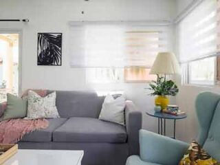Cozy apartment living area with minimalist decor, a gray sofa, and pastel blue armchairs.