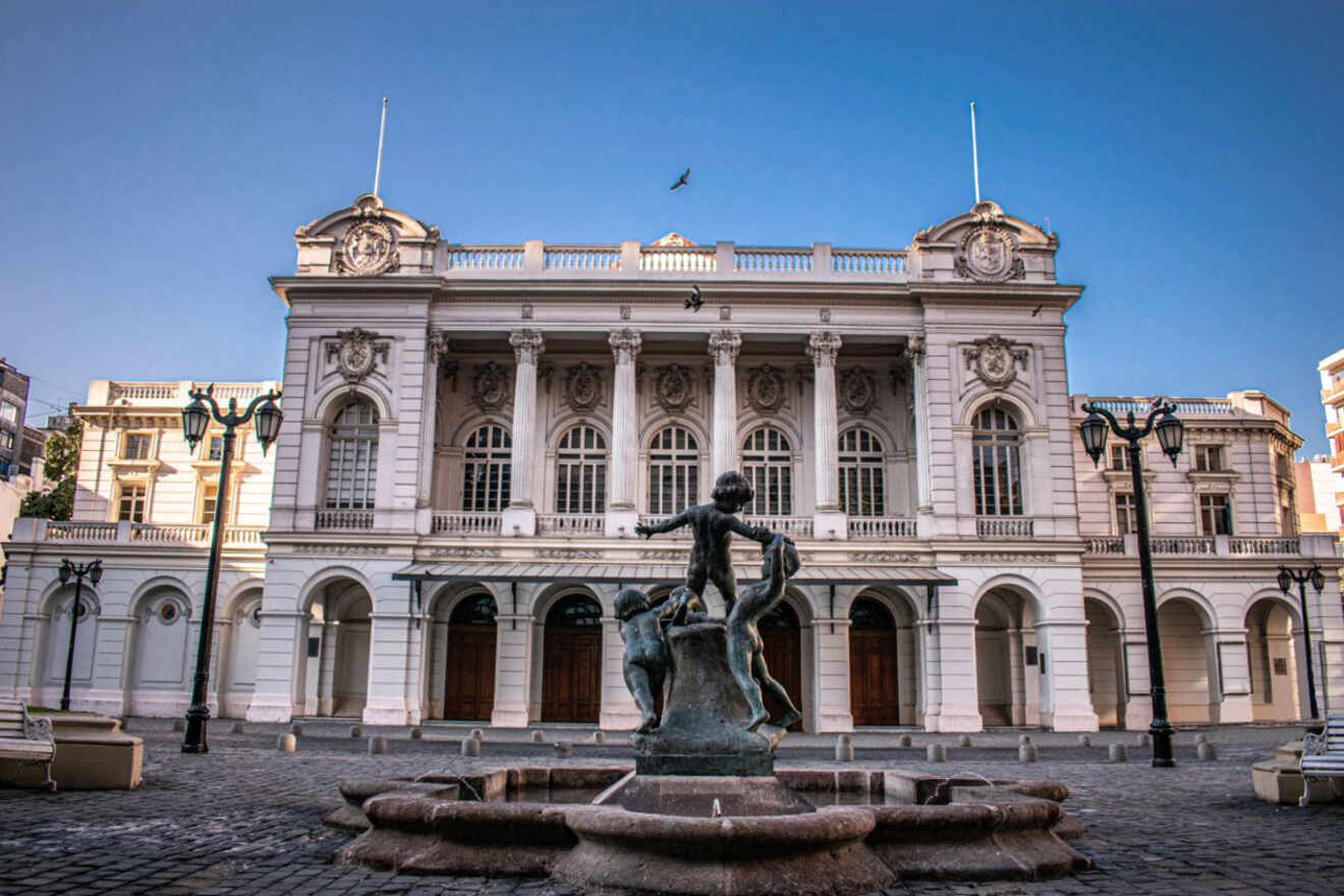 The historic Municipal Theatre of Santiago building in Santiago, Chile, with a foreground statue and clear blue skies