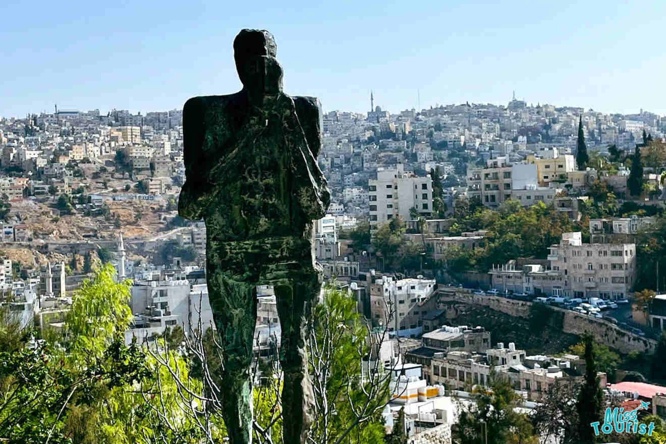 A silhouette of a statue overlooking the cityscape of Amman, Jordan, suggesting a blend of art and urban scenery at Darat al-Funun art gallery