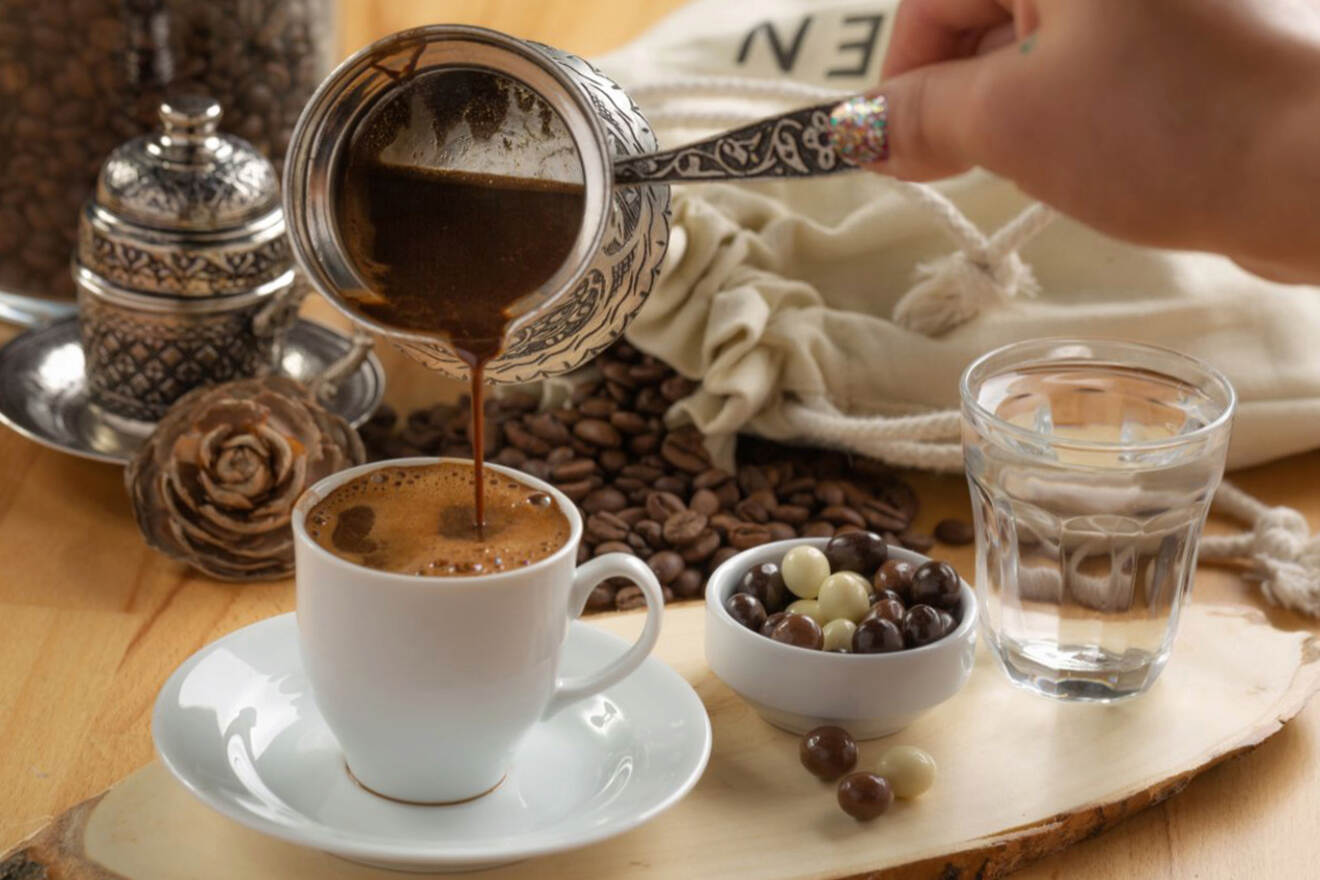 A close-up shot of a traditional Serbian coffee service, with a hand pouring coffee into a cup, accompanied by chocolate-covered candies