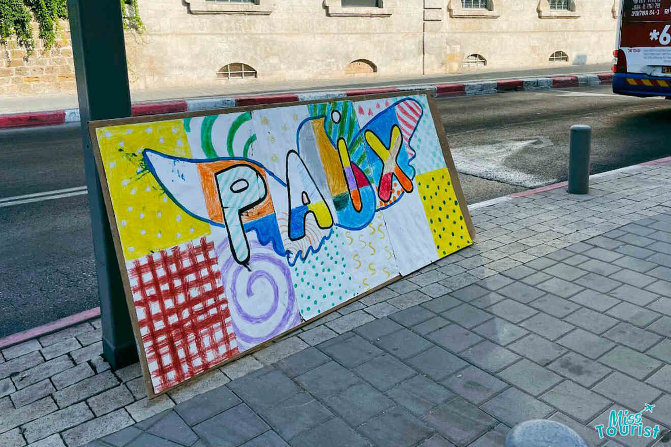 Colorful street art on display in Tel Aviv, featuring abstract patterns and the word 'Pax' in large, playful letters against an urban backdrop