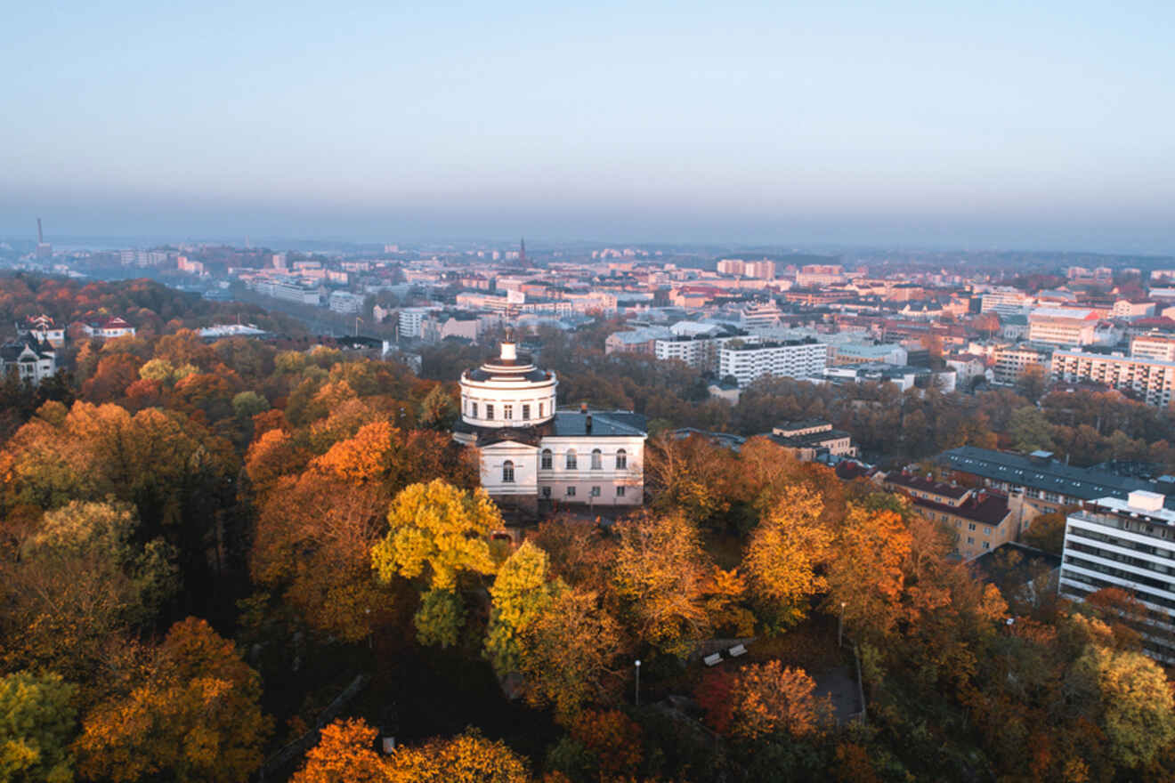 Twilight over Vartiovuori Observatory, enveloped by the vibrant autumn foliage of Vartiovuori Park, with the cityscape of Turku in the distance
