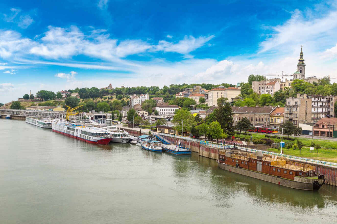 Scenic view of the Belgrade waterfront showing a row of docked riverboats along the Sava river with the historic district in the background