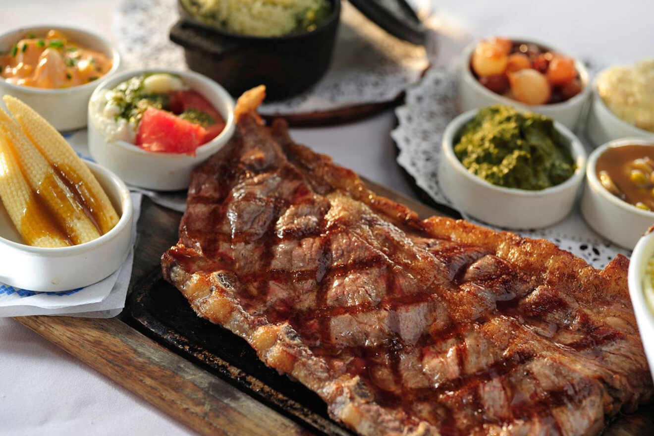 A traditional Argentine culinary spread featuring a large, juicy grilled steak accompanied by a variety of side dishes
