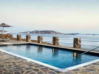 Infinity pool at a beachside hotel with a view of the Mykonos coastline and ocean