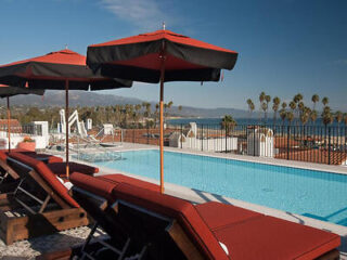Rooftop pool at Hotel Californian with loungers overlooking a panoramic beach view