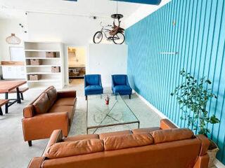 Retro-styled living area in ITH Santa Barbara Beach Hostel with leather sofas and unique decor.