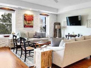 Modern living area in the Secret Riverfront Sanctuary with chic decor, exposed brick, and a welcoming atmosphere.