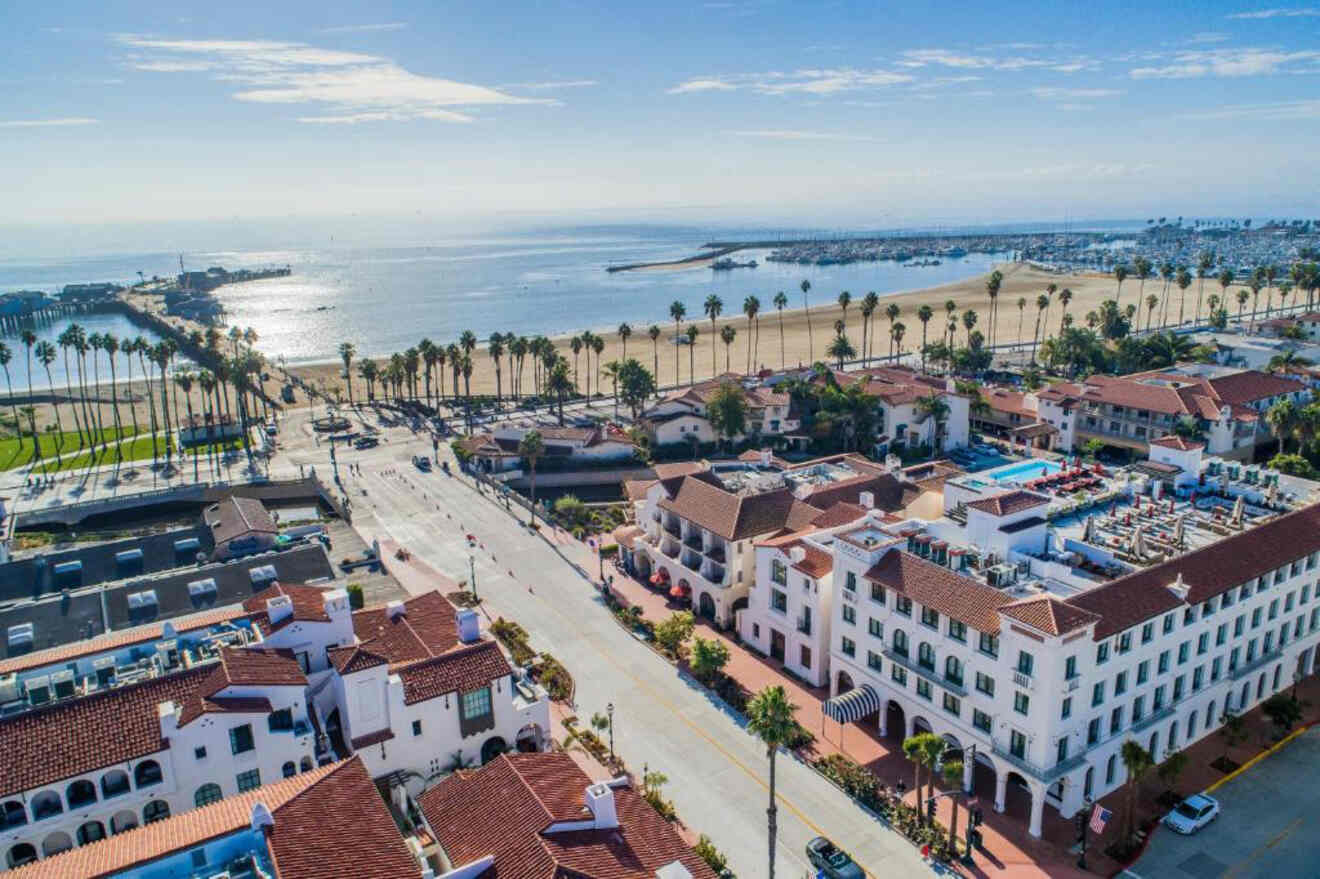 Aerial view of Santa Barbara's Funk Zone featuring Spanish-style architecture, palm-lined streets, and a view of the beach and pier, encapsulating the essence of a vibrant beachside community.