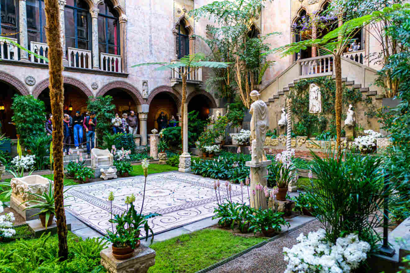 Lush indoor garden courtyard inside the Isabella Stewart Gardner Museum in Boston, with visitors admiring the classical architecture and verdant plant arrangements