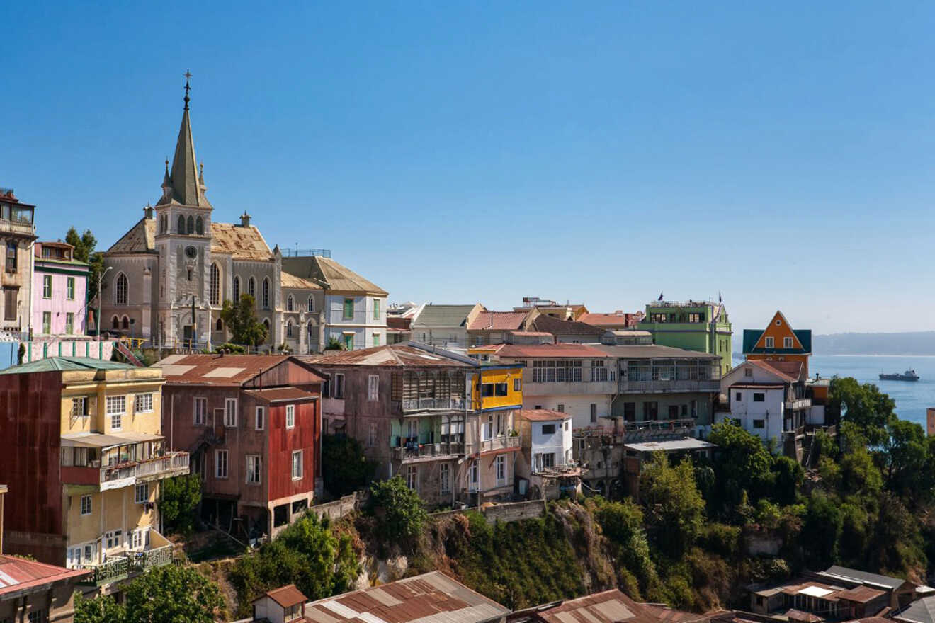 A picturesque view of Valparaiso, Chile, showing colorful hillside homes and a historic church overlooking the Pacific Ocean