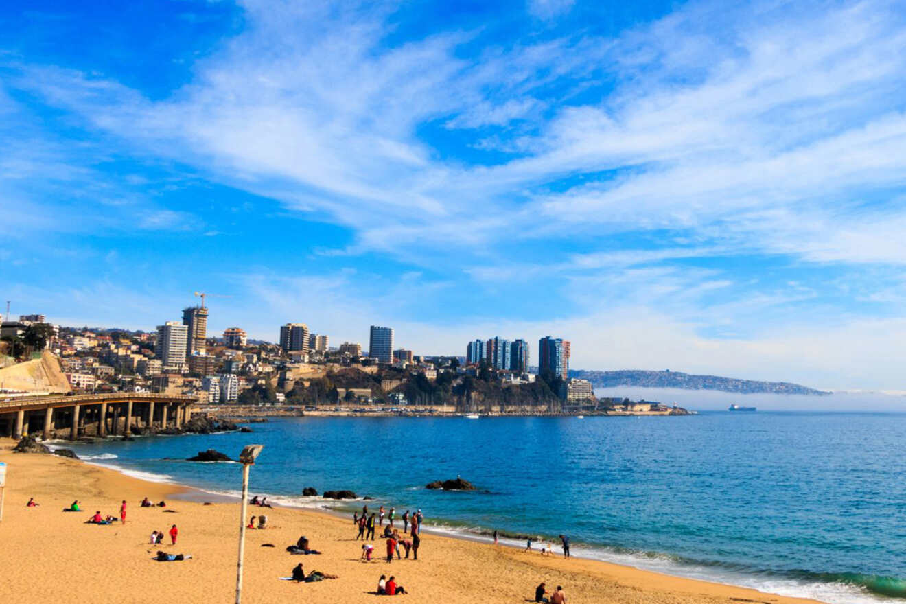 Sunny beach day at Viña del Mar, Chile, with people enjoying the sandy shores and the city's coastal skyline in the background