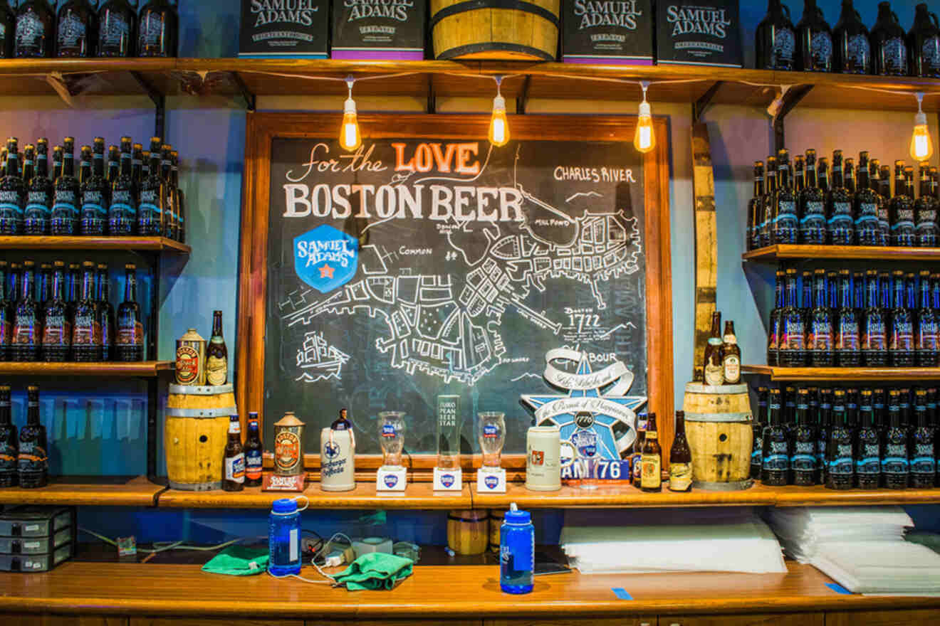 Interior of Samuel Adams Brewery in Boston displaying an array of craft beer bottles and a chalkboard map highlighting the 'Love of Boston Beer'