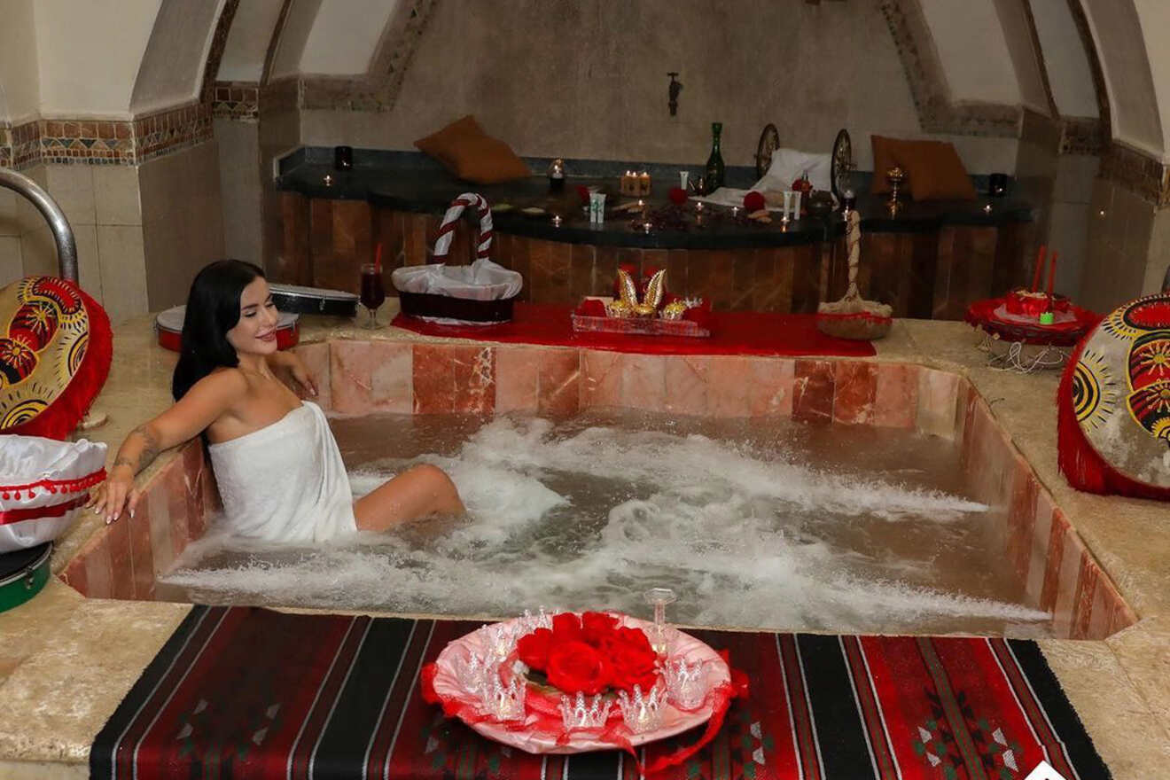 A woman enjoying a luxurious bath in the Al Pasha Turkish Bath in Amman, Jordan, surrounded by traditional décor and a festive atmosphere