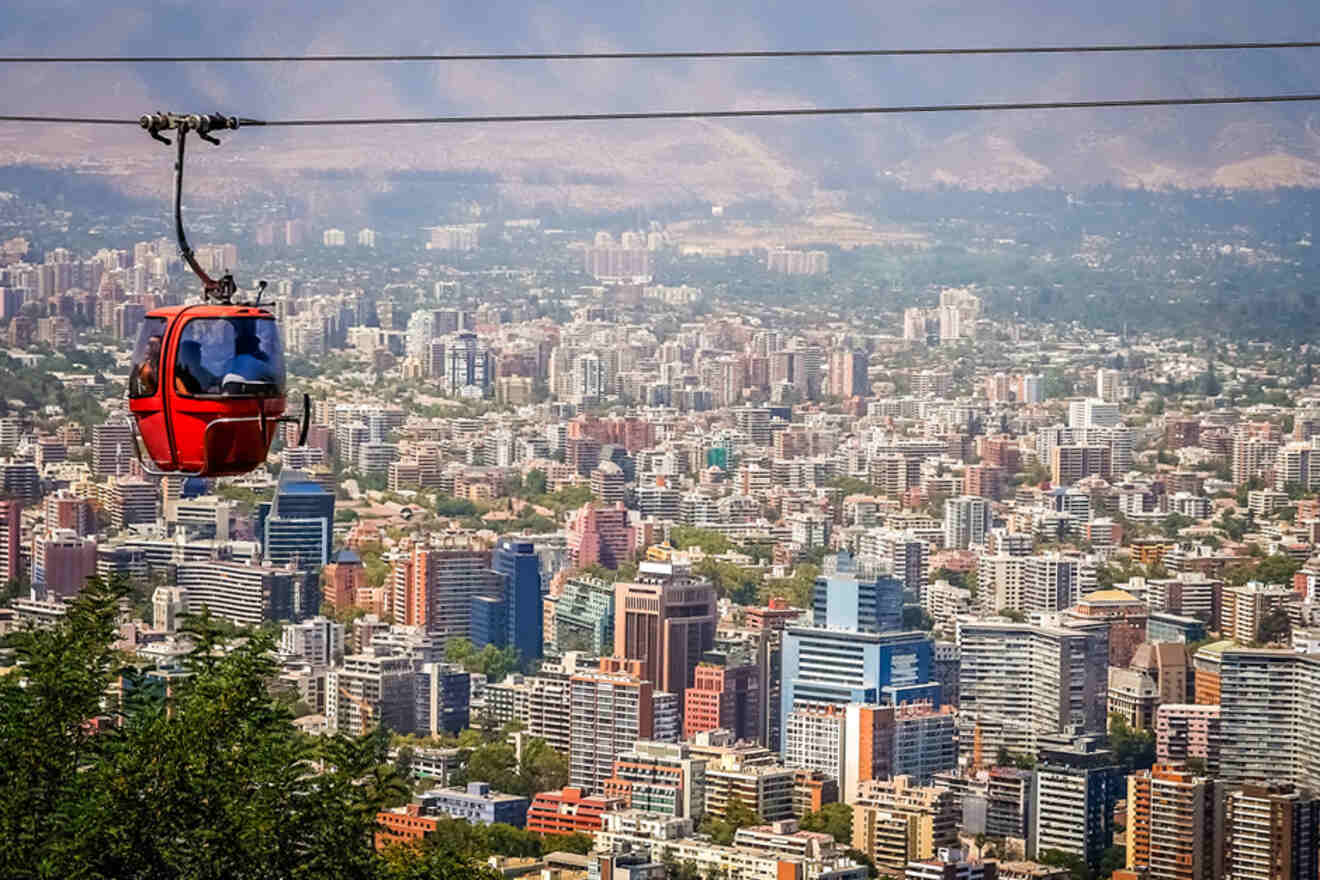 Aerial view of Santiago, Chile, from a red cable car, showcasing the vast cityscape with mountains in the distance