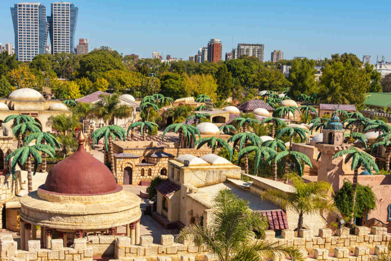 Aerial view of Tierra Santa, Buenos Aires, displaying the unique theme park's miniature biblical-era city replicas and palm trees, with modern buildings in the backdrop