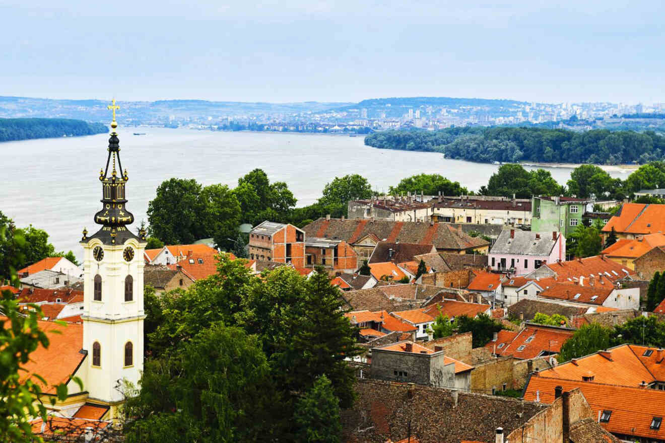 Scenic view from Zemun, Belgrade, overlooking red-roofed houses with the Church of St. Nicholas and the confluence of the River Danube in the background