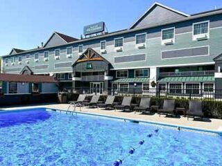 Hotel exterior with a clear blue swimming pool surrounded by loungers, inviting guests for a refreshing outdoor swim.