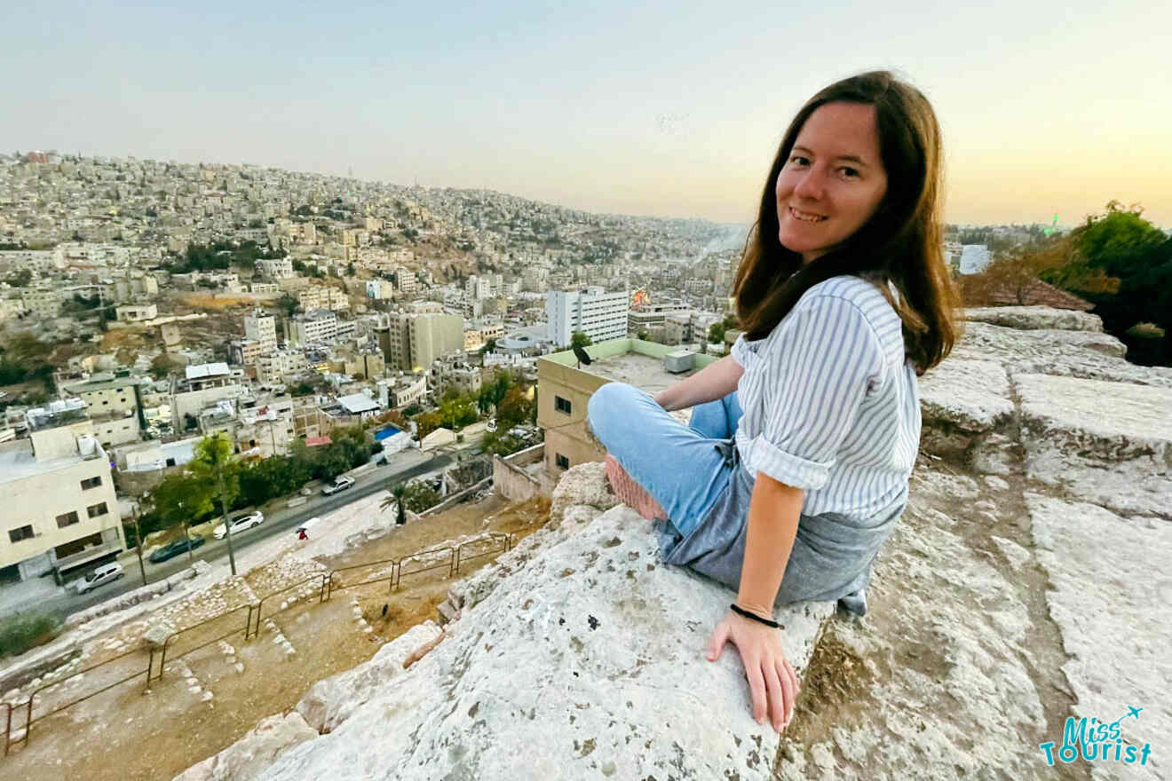 The writer of the post seated on ancient ruins at Amman Citadel with a sweeping view of the city during dusk