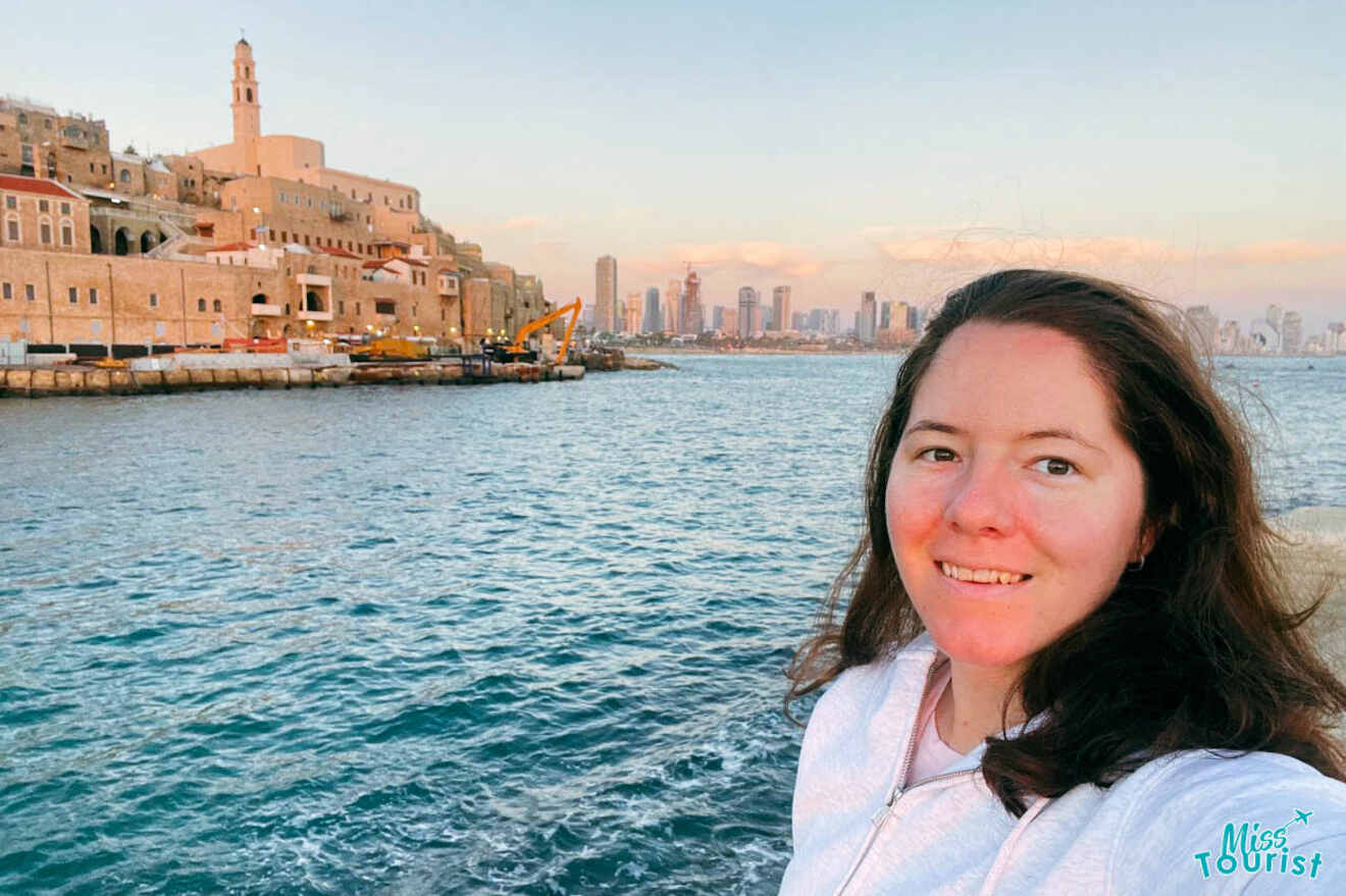 Selfie of the writer of the post with the historic buildings of Old Jaffa in the background during sunset, with a view of the Mediterranean Sea and the Tel Aviv skyline