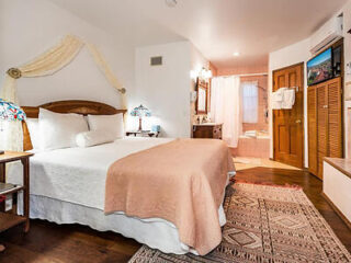 "Charming Bath Street Inn bedroom with a vintage bed and warm lighting