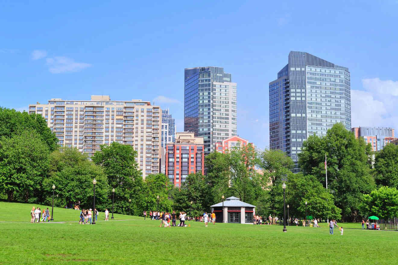 Boston Common on a sunny day, featuring people enjoying the vast green space with the city's modern skyline rising in the background