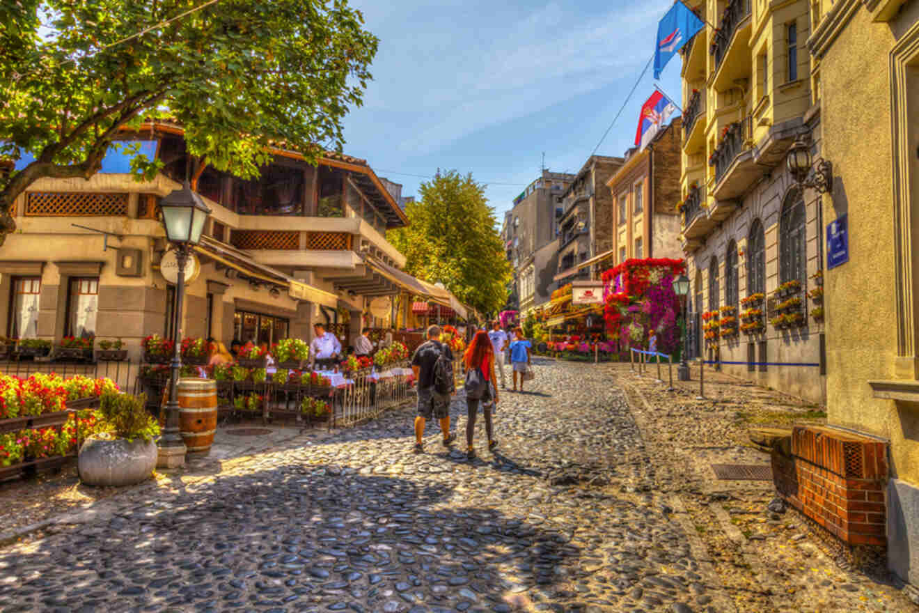 The charming cobblestone street of Skadarlija, Belgrade's bohemian quarter, adorned with colorful flowers and bustling with café culture
