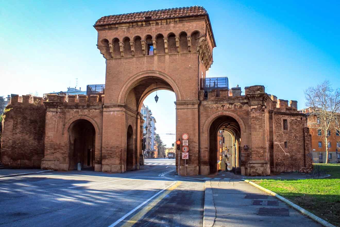 The historical Porta Saragozza of Bologna, showcasing the ancient city gate with its arches and watchtowers against a clear blue sky.