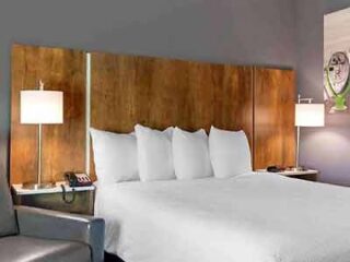 Extended Stay America Premier Suites in Savannah, showcasing a sleek room with a large wooden headboard and modern furnishings.