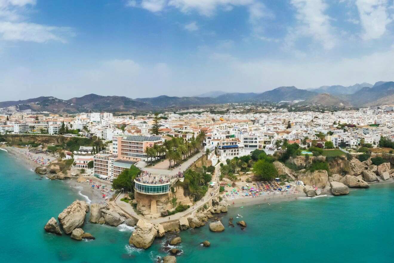 Panoramic view of Nerja, Málaga, showcasing the beach cove with azure waters and the town against a mountainous backdrop