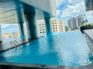 A rooftop infinity pool with cityscape views, supported by large pillars, providing a refreshing urban escape.