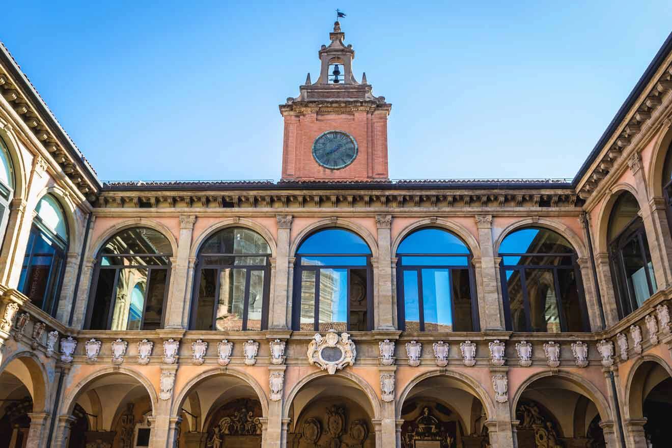 The elegant arcade of the University of Bologna with a grand clock tower, showcasing the institution's historic architecture and academic heritage.