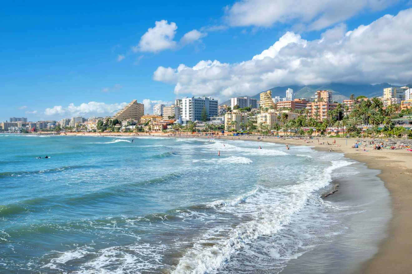 Playa de Huelin, Málaga, featuring a vibrant beach scene with palm trees and urban surroundings