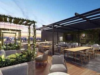 A rooftop dining area with comfortable seating, lush plant arrangements, and modern design elements, offering an upscale urban dining experience.